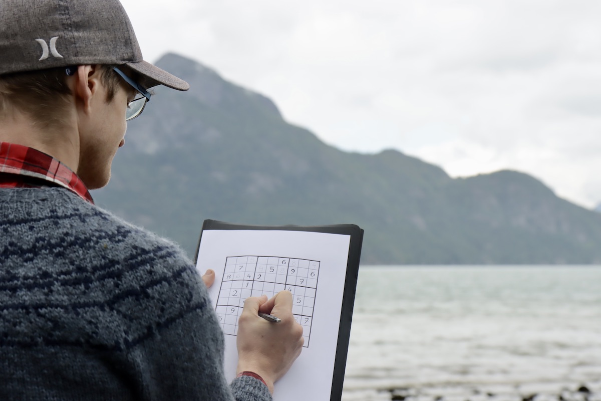 Solving a sudoku by the lake.